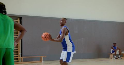 Male basketball player shooting free throw in indoor gym during team practice session