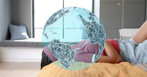 Woman holding smartphone on bed with augmented reality globe overlay for tech lifestyle