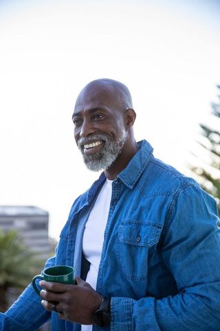 Senior african american man enjoying rooftop leisure with coffee