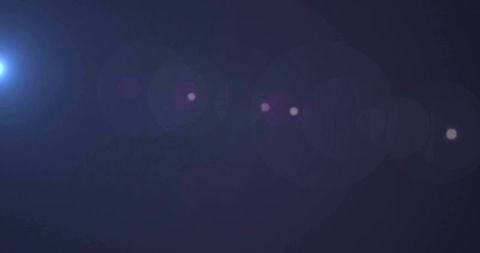 Left-side bright lens flare casting purple bokeh and halo on dark gradient backdrop