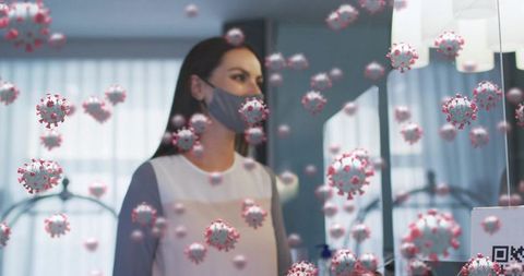 Woman wearing gray mask at reception scanning QR code amid floating coronavirus particles