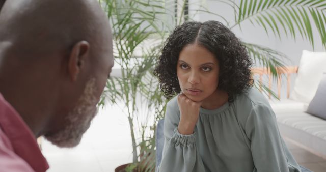 Unhappy woman talking to man in therapy session with green plants in background - Download Free Stock Images Pikwizard.com