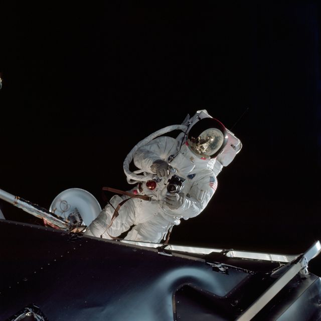 Astronaut Russell L. Schweickart, lunar module pilot, operates a 70mm Hasselblad camera during his extravehicular activity on the fourth day of the Apollo 9 earth-orbital mission. The Command/Service Module and the Lunar Module 3 "Spider" are docked. This view was taken form the Command Module "Gumdrop". Schweickart, wearing an Extravehicular Mobility Unit (EMU), is standing in "golden slippers" on the Lunar Module porch. On his back, partially visible, are a Portable Life Support System (PLSS) and an Oxygen Purge System (OPS). Film magazine was A,film type was SO-368 Ektachrome with 0.460 - 0.710 micrometers film / filter transmittance response and haze filter,80mm lens.