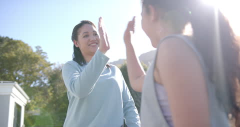 Mother and Daughter Celebrating with a High Five Outdoors