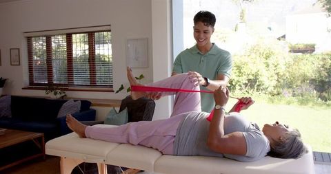 Physiotherapist Guides Senior Woman in Leg Exercises for Rehabilitation