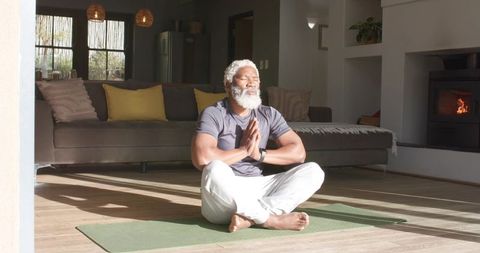 Mature Man Embracing Meditation at Home in Sunlit Living Room