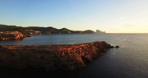 Golden Hour Rocky Promontory Stretching into Calm Sea at Sunset Drone Panorama