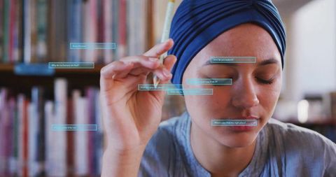 Focused student with navy headwrap holding pencil, visual ar prompts overlay in library