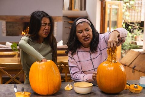 Mother and Daughter Scooping Pumpkins during Autumn Crafts