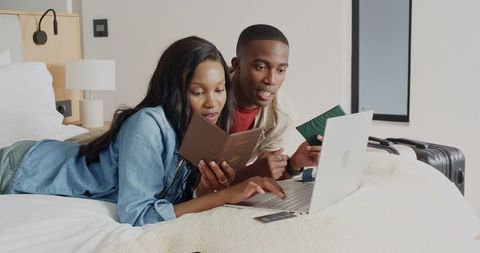 African couple planning travel adventure using laptop