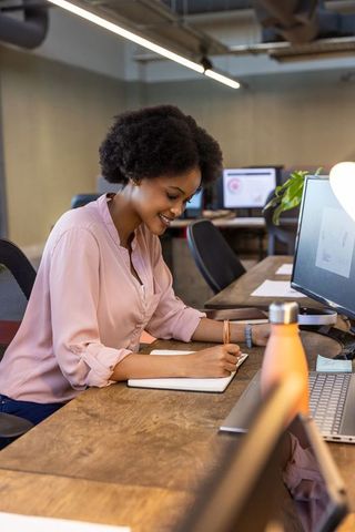 Focused african american woman writing in office environment