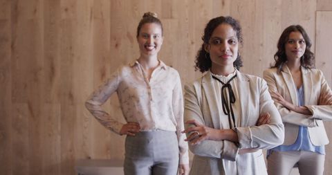 three women colleagues stand confidently in a modern office, expressing leadership and diversity. this image represents empowerment and teamwork in a professional setting. it is perfect for illustrating business success, collaboration, women in leadership roles, or diversity in the workplace.