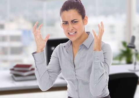 Stressed businesswoman at office desk expressing frustration