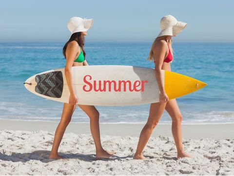 Women Walk on Sandy Beach with Surfboard Showcasing Warmth