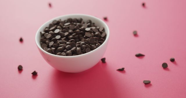 Image of bowl of chocolate chip over pink background. fusion food, chocolate and sweets concept.