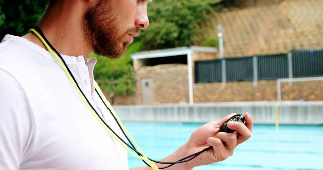 Focused Swimming Coach Timing Swimmer at Poolside - Download Free Stock Images Pikwizard.com