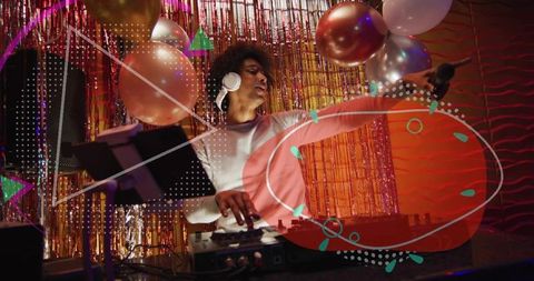 Energetic dj performing with headphones and microphone in festive metallic fringe party booth