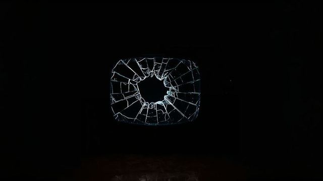 Cracked crt screen in dark room with reflective floor