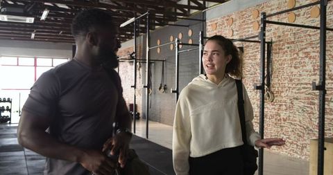 Diverse gym partners discussing fitness routine indoors