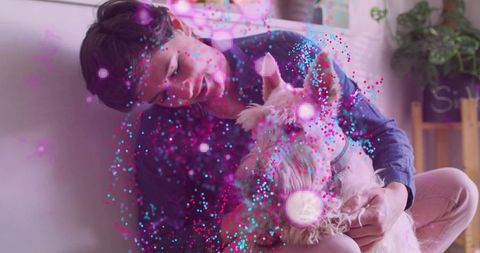 Woman cradling fluffy dog on sofa surrounded by vibrant pink and blue particle effects