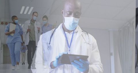 masked doctor using tablet with covid-pandemic healthcare team - Download Free Stock Images Pikwizard.com