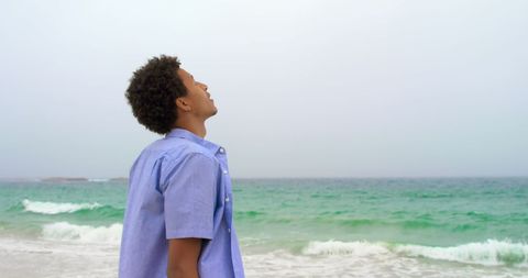 Reflective Young Man Gazing Over Serene Ocean Waves