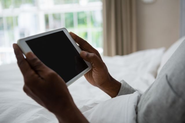 Senior Man Holding Digital Tablet While Resting on Bed - Download Free Stock Photos Pikwizard.com