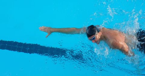 Male Swimmer Practicing Freestyle in Blue Pool