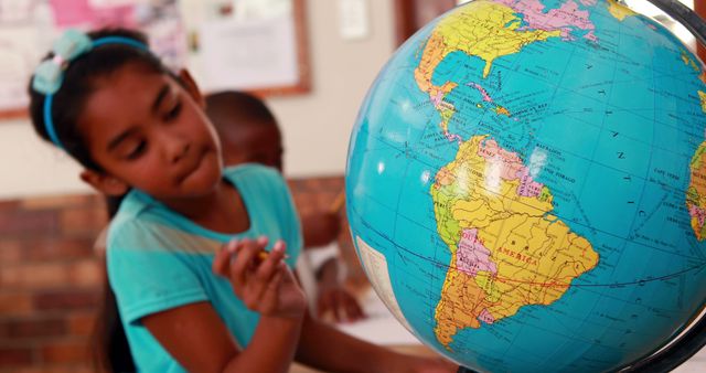 Young girl actively engaged in learning geography by analyzing a globe. Ideal for educational content, learning resources, school websites, and materials promoting geography and global education.