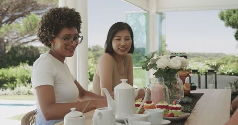 Friends Enjoying Refreshments at Scenic Outdoor Garden Event