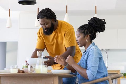 African american couple preparing breakfast table in modern kitchen sharing morning moment