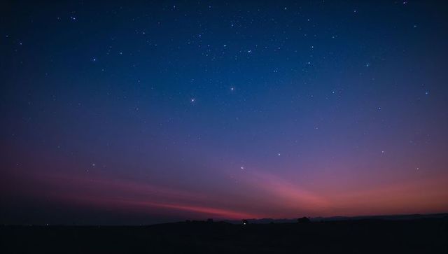 Twilight Sky with Stars and Horizon Glow Above Silhouetted Hills