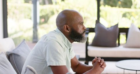 Pensive Man Relaxing on Sofa in Thoughtful Contemplation