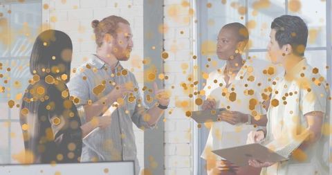 Team collaborating and discussing plans in modern loft office with laptops and tablet