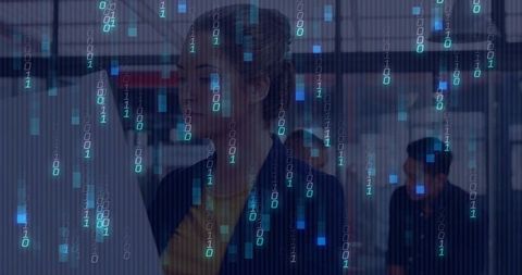 Professional woman analyzing data on monitor with binary overlay in modern glass office