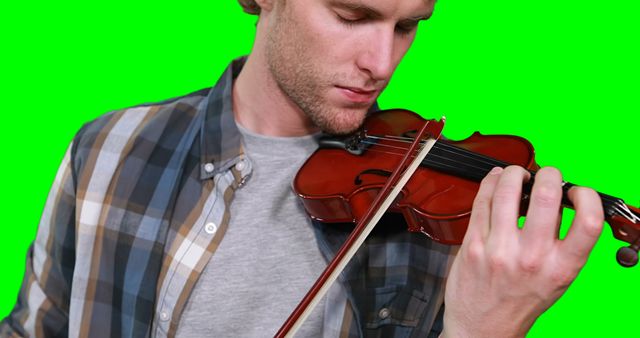 Close-up of male musician playing violin against green screen