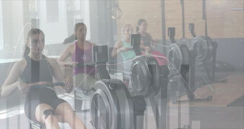 Women rowing on machines integrated with digital data interface