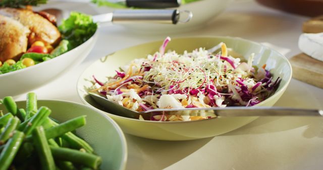 Fresh coleslaw bowl with a variety of vegetables on a dining table. The image emphasizes healthy eating and colorful, fresh ingredients. Ideal for use in blogs, websites, and articles focused on nutrition, recipes, vegan and vegetarian diets, or healthy lifestyle content.