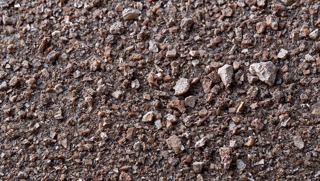 Close-up crushed gravel soil texture with angular rock fragments for backgrounds
