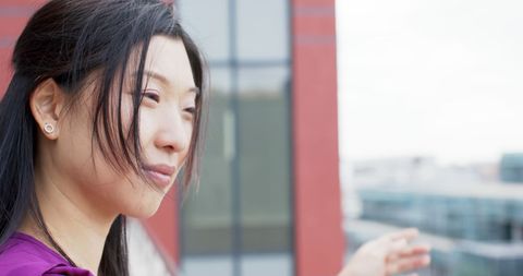 Confident asian businesswoman outdoors with office building backdrop