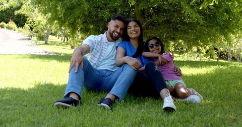 Happy Family Bonding Under Tree in Sunny Park