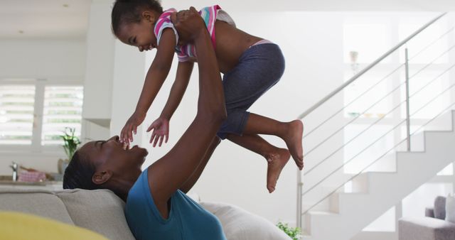 Loving Mother Lifting and Playing with Young Daughter at Home - Download Free Stock Images Pikwizard.com