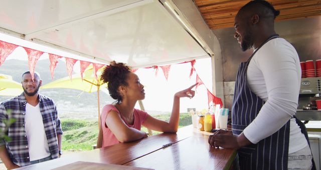 Smiling Customers Interacting with Food Truck Vendor at Outdoor Market - Download Free Stock Images Pikwizard.com