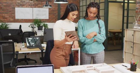Colleagues Collaborating Over Scale Model in Modern Office