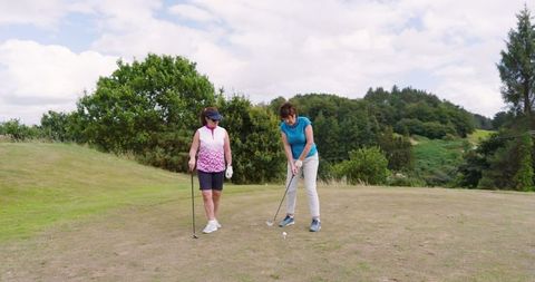 Female golfers enjoying sport on beautiful hilltop course