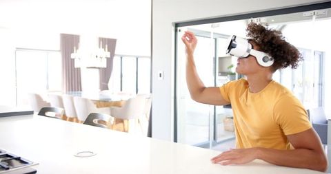 Young person experiencing virtual reality in modern kitchen