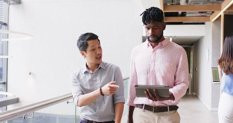 Business Colleagues Discussing Work with Tablet in Modern Office
