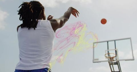 Shooting jump shot with vibrant color trail on outdoor basketball hoop