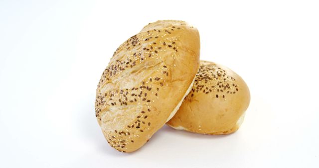 Ideal for use in advertisements related to bakeries, food products, recipes, or nutrition. Perfect for culinary websites, cooking blogs, menu design, or educational purposes to illustrate various types of bread. The clean composition highlights the texture and details of the sesame seed buns, making them visually appealing for marketing and promotional materials.