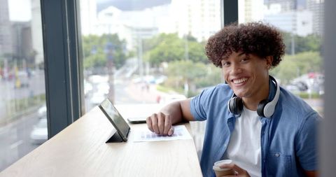 Young Man Smiling at Work with Tablet and Coffee in Modern Office - Download Free Stock Images Pikwizard.com